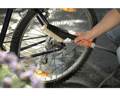 Reinigung eines Fahrrads mit Bürste und Wasserschlauch