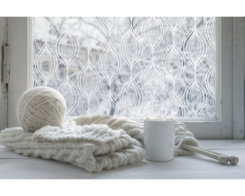 Dekorfolie am Fenster mit Strickzeug und Getränk
