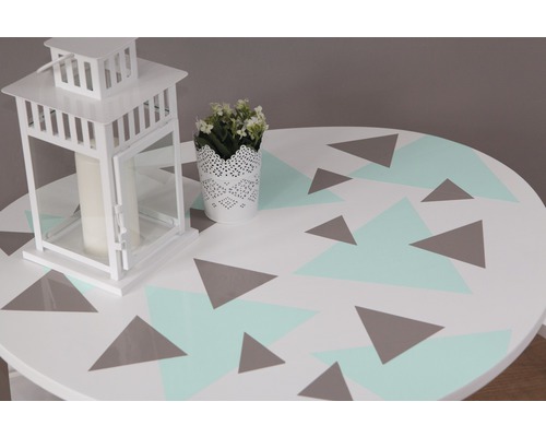 Table décorative avec motif géométrique, lanterne et plante en pot