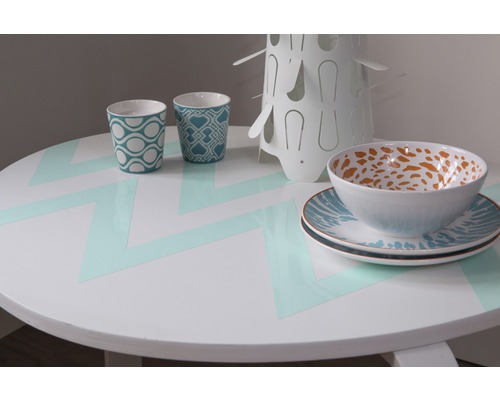 Table ronde dressée avec vaisselle et gobelets