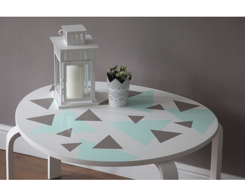 Table décorative avec motif géométrique, lanterne et plante en pot
