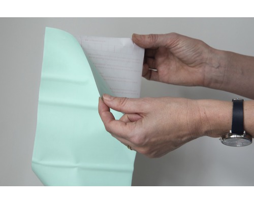 Une personne retire le film protecteur d''un film.