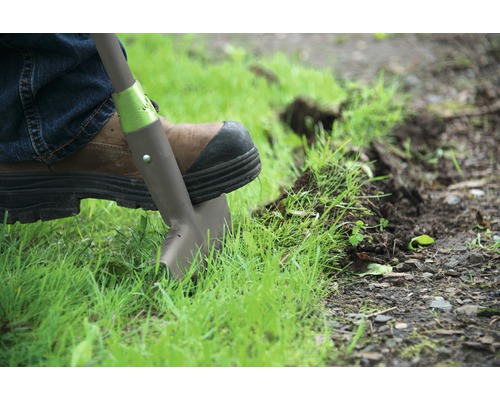 Personne avec une bêche pour délimiter une pelouse