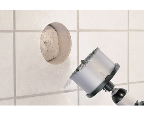 Perceuse à carreaux perçant un trou dans un carreau blanc