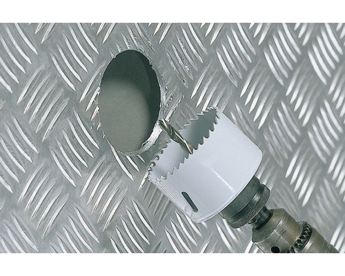 Scie cloche perçant un trou dans une plaque de métal