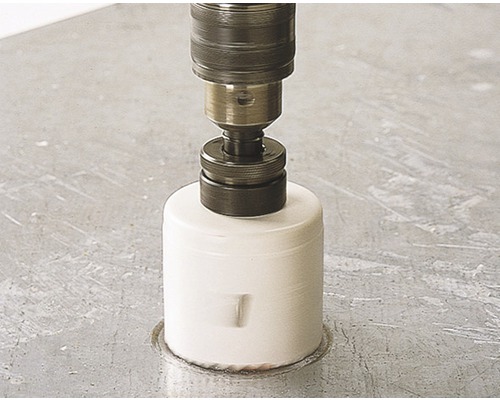 Scie cloche en cours d''utilisation avec une perceuse sur une surface de travail