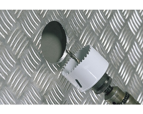 Scie cloche perçant un trou dans une plaque de métal