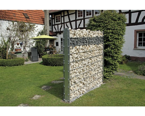 Mur de gabions dans le jardin avec une maison en arrière-plan