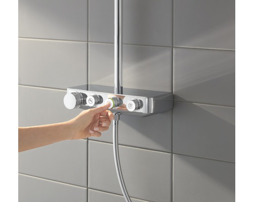 Person bedient Duscharmatur mit Reglern zur Steuerung von Wasserfluss und Temperatur