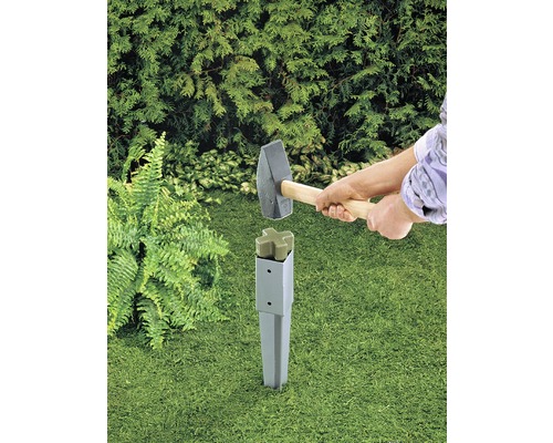 Person schlägt mit Hammer Erdanker in den Boden im Garten