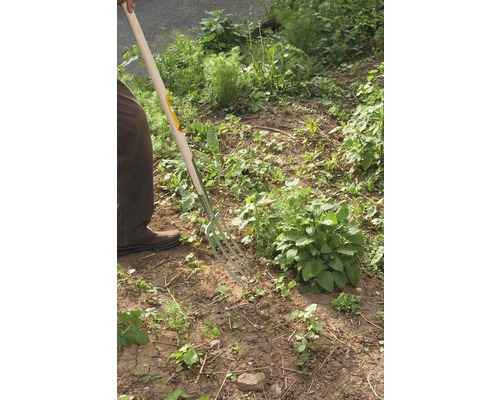 Jardinier utilisant une fourche bêche dans le jardin.