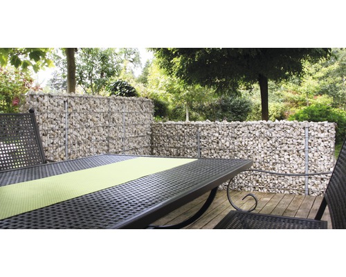 Gartenszene mit Gabionenwand und Metalltischgarnitur auf einer Holzterrasse