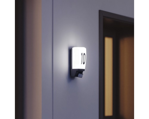 Beleuchtetes Hausnummernschild mit der Nummer 10 an der Wand