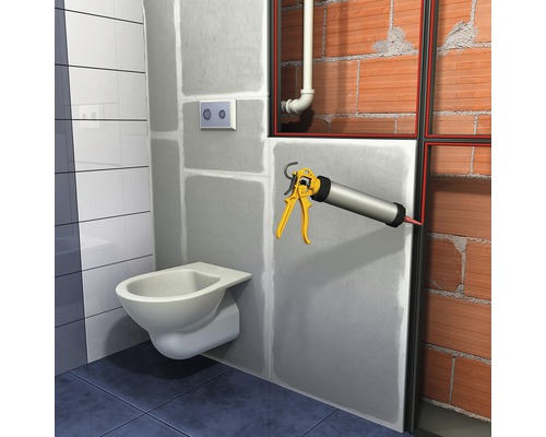 Scène de salle de bains avec installations sanitaires, murs de construction sèche et pistolet à calfeutrer