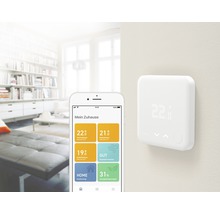 Tado Smart Heizkörperthermostat mit Smartphone in einem modernen Wohnzimmer