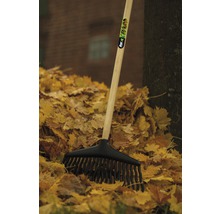 Laubbesen mit Holzstiel und schwarzem Kunststoffkopf im Laubhaufen