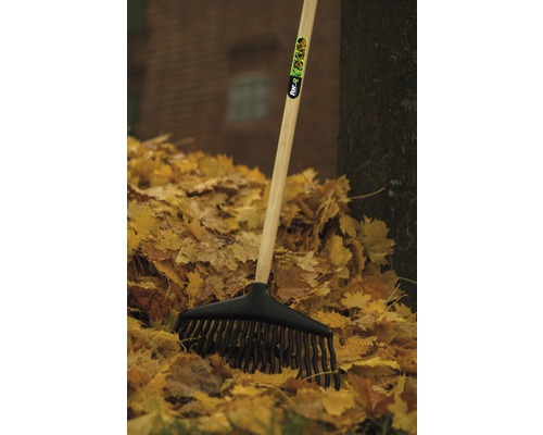 Laubbesen mit Holzstiel und schwarzem Kunststoffkopf im Laubhaufen