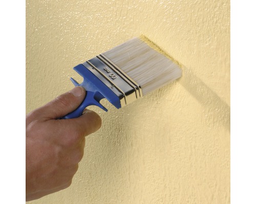 Une personne peint un mur avec un pinceau de 100 millimètres de large.