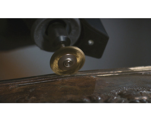 Brosse métallique rotative fixée sur un outil multifonction travaillant sur du métal