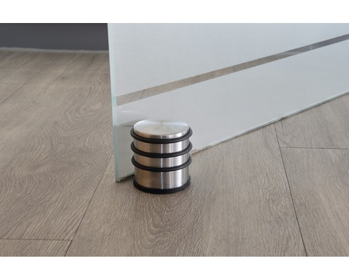 Butoir de porte en acier inoxydable devant une porte en verre