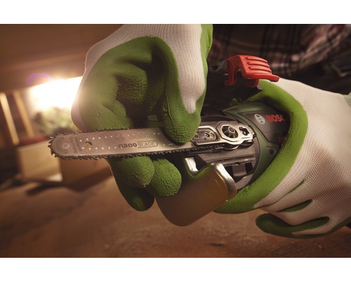 Personne gantée tenant une tronçonneuse sans fil Bosch avec lame de scie NanoBlade