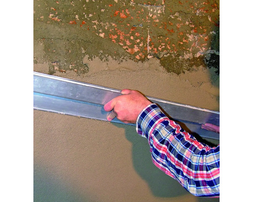 Une personne lisse du plâtre sur un mur à l''aide d''une truelle à plâtre.