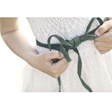 Femme nouant un nœud sur une robe blanche