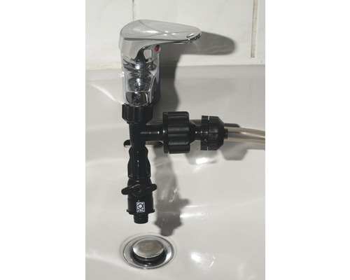 Auf einem Waschbecken ist ein Wasserhahn mit einem Wasserstrahlregler montiert.