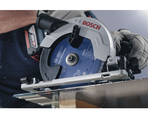 Scie circulaire portative Bosch coupant du bois avec des gants