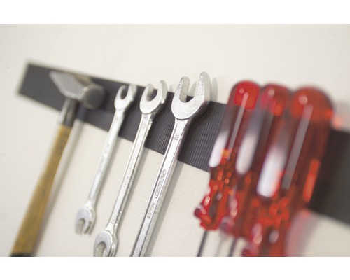 Marteau, clés et tournevis sur une barre à outils magnétique