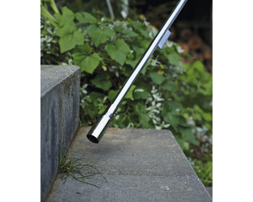 Detailaufnahme eines Edelstahlhandlaufs an einer Betontreppe im Aussenbereich.