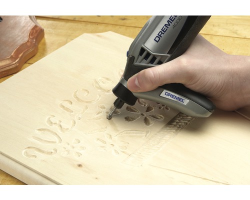 Outil multifonction Dremel gravant un morceau de bois.