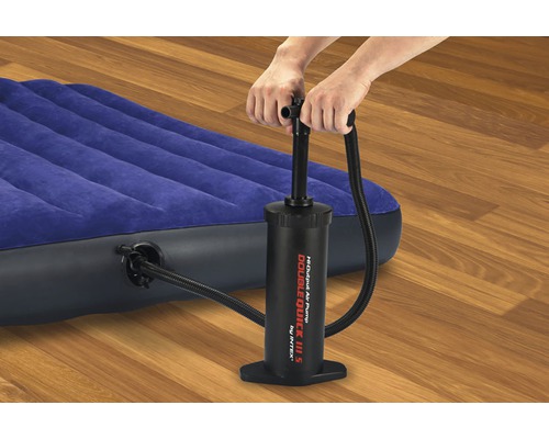 Une personne gonfle un matelas pneumatique bleu à l''aide d''une pompe à air