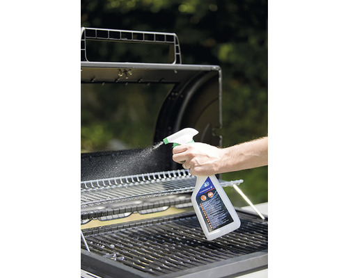 Une personne nettoie une grille de barbecue avec un nettoyant pour barbecue en spray.