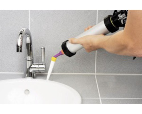 Application de produit d''étanchéité avec un pistolet à cartouche sur un lavabo