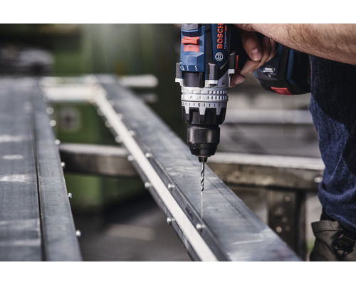 Perceuse sans fil perçant un trou dans un profilé métallique