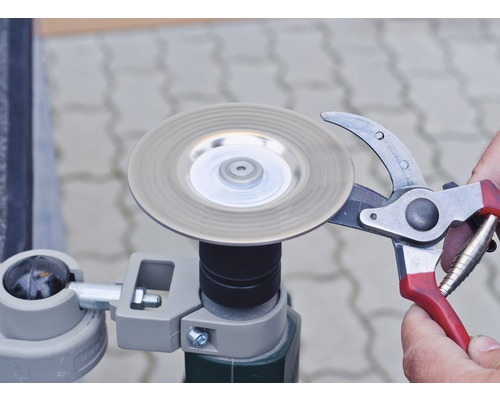 Gartenschere wird mit einem Schleifgerät geschärft