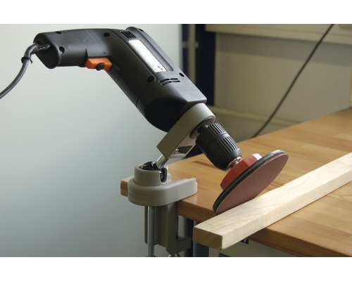 Bohrmaschine mit Schleifscheibe an einem Werkstück befestigt