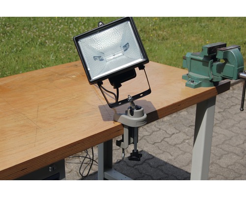 Baustrahler mit Schraubzwinge auf Werkbank