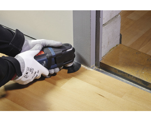 Bediener verwendet Multifunktionswerkzeug zum Sägen auf Holzboden