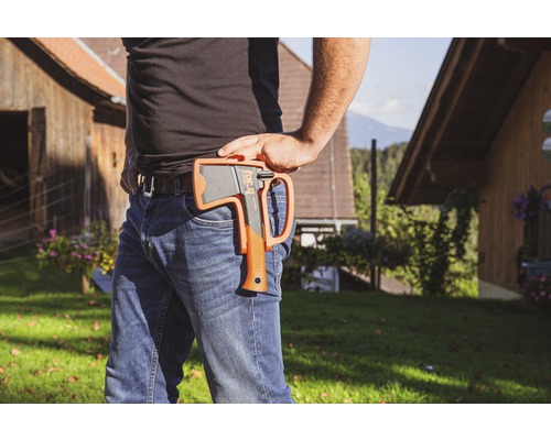 Person mit Axt im Halfter am Gürtel in Aussenaufnahme.