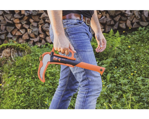 Un homme tient une hache for_q avec protège-mains sur fond de pile de bois et d''espace vert.