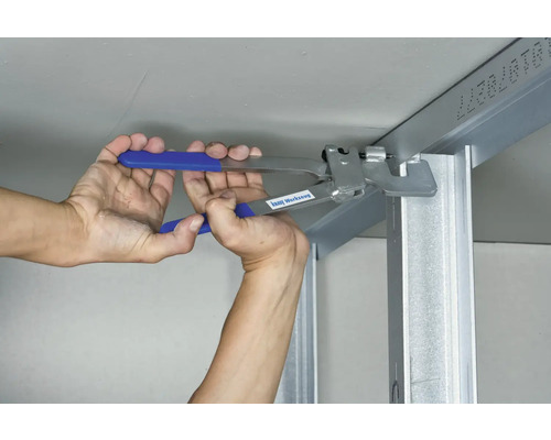 Une personne fixe un profilé métallique à un plafond à l''aide d''une pince.