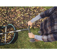 Vue de dessus d''une personne utilisant un ramasse-feuilles sur une pelouse avec des feuilles d''automne