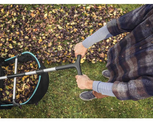 Vue de dessus d''une personne utilisant un ramasse-feuilles sur une pelouse avec des feuilles d''automne