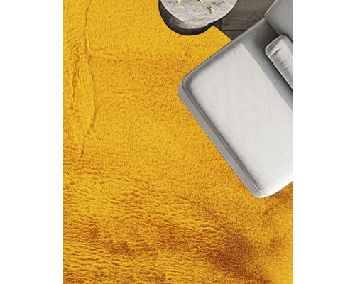 Detailansicht eines Zimmers mit einem Teppich, einem Sofa und einem Tisch.