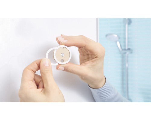 Personne installant un accessoire de salle de bain au mur