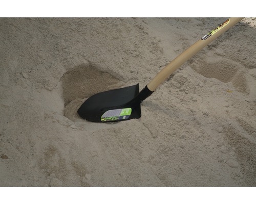 Pelle avec manche en bois dans le sable