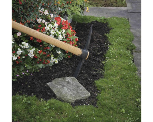 Scène de jardinage avec une pioche, des fleurs et de l''herbe