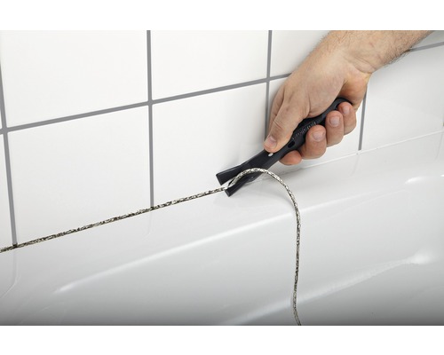 Élimination du mastic avec un outil de suppression de joints dans la salle de bain